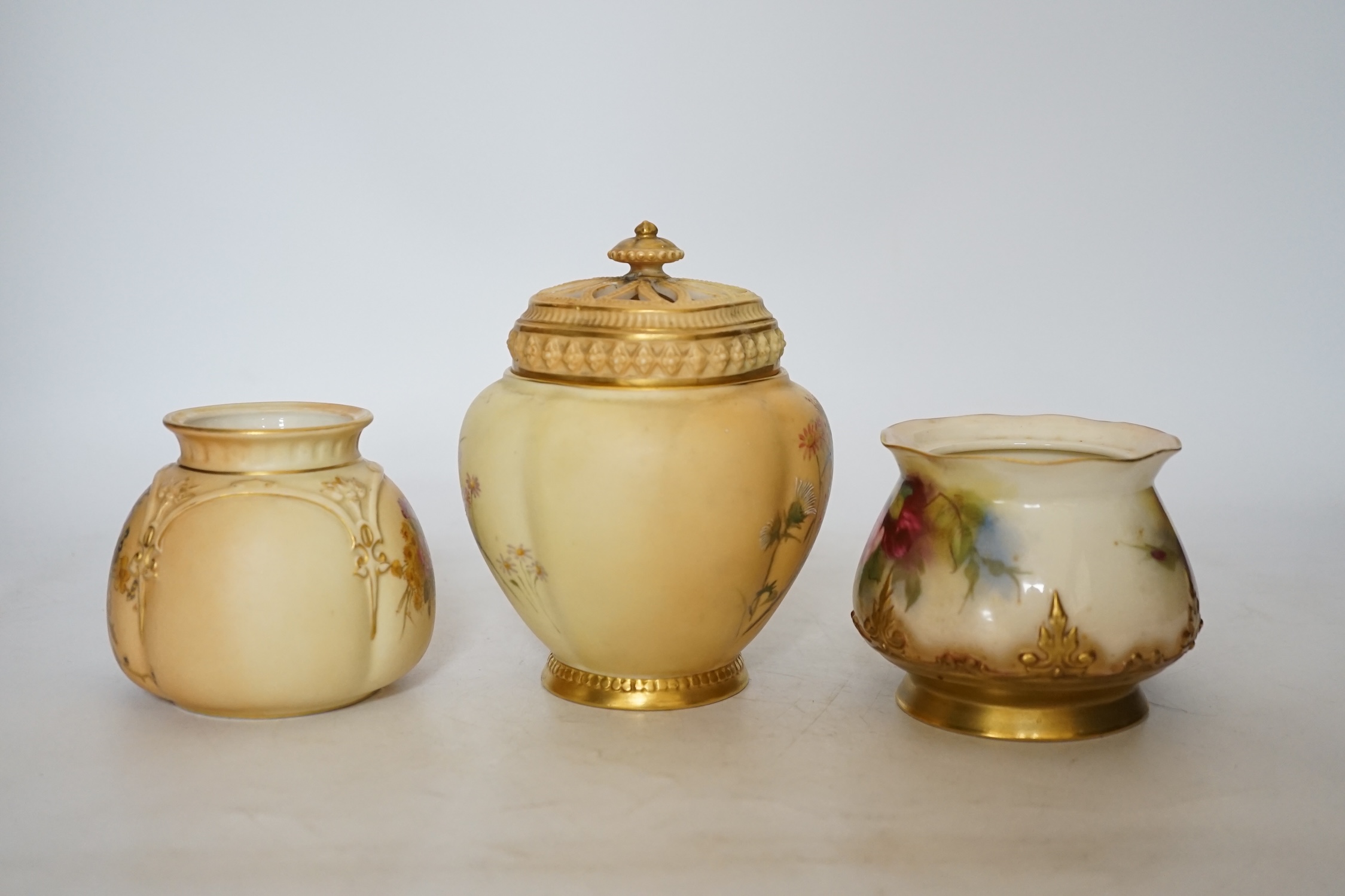 Three Royal Worcester blush ivory pots, one with an inner lid and pierced outer lid, tallest 14cm